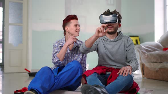 Positive Man in VR Headset Gesturing Discussing Virtual Renovation Design with Smiling Woman Talking
