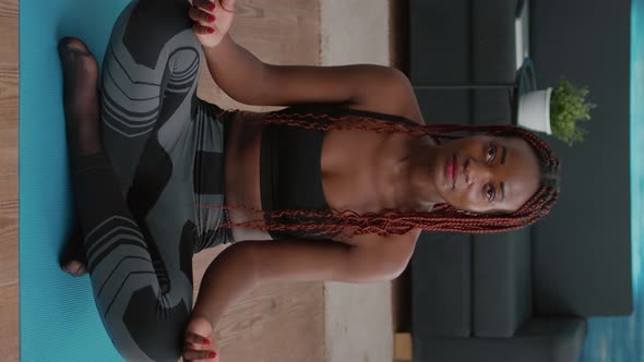 Verical Video Portrait of Black Woman Sitting in Lotus Position on Floor Doing Morning Breathing