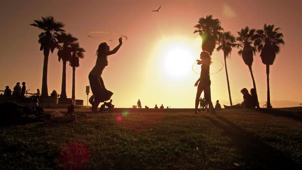 Lens flare shot of people strolling near Venice Beach, California filmed in slow motion