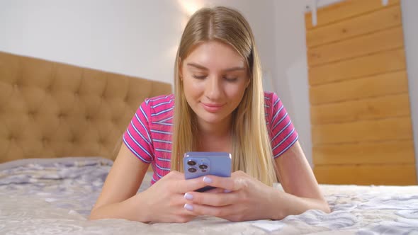 Cheerful young woman using modern smartphone for online communication with smile in 4k video
