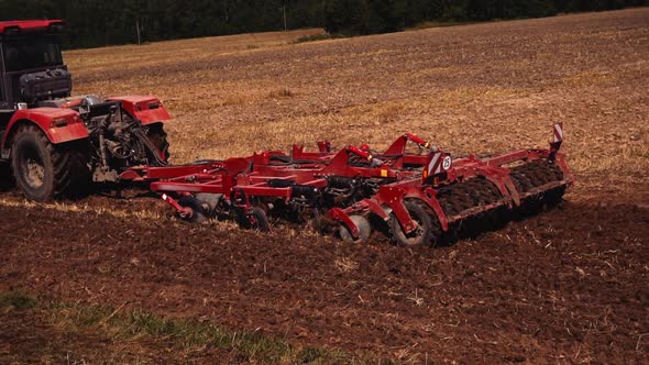 Tractor on land cultivating. Tractor with disk harrow system plowing ground on cultivated farm