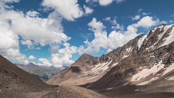 Clouds over the mountains valley with snow