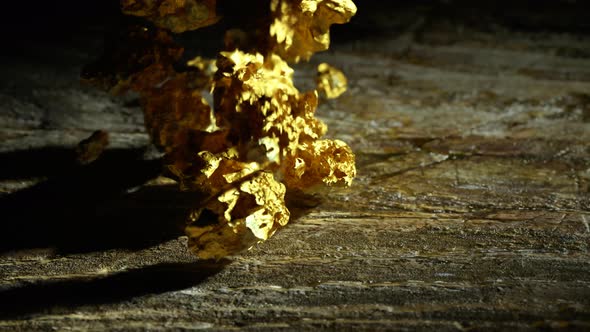 Gold nuggets are thrown on an old wooden surface. Wealth, success, treasure