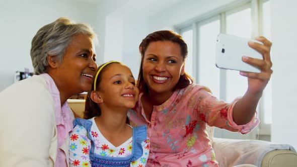 Happy family taking a selfie with mobile phone in living room 4k