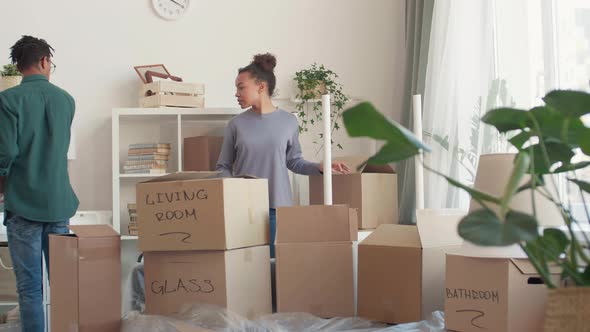 Young Couple Packing Things for Move