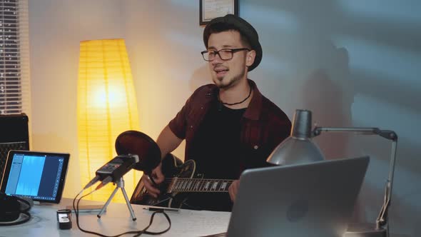 Home Recording Studio: Cheerful Musician Playing Guitar and Emotionally Singing His Hit Song