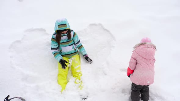 Mom with a Three-year-old Daughter Play Snowballs