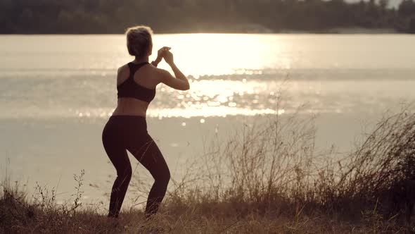 Fit Sporty Woman Squats Exercising At Sunset. Stretching Fitness Workout Activity. Squats Workout