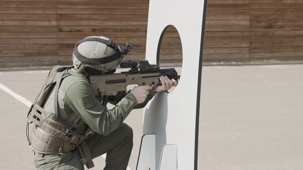 Slow motion of soldier shooting automatic rifle in a range alt