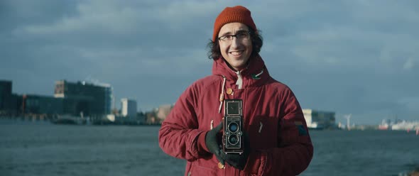 Young man taking picture with vintage camera