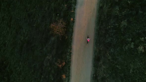 Drone Footage of Woman Cyclist in Sunset on Bike