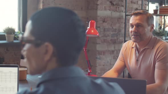 Businessman Listening to Colleagues at Team Meeting