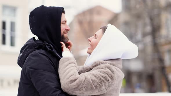 Beautiful Man and Woman in the Winter on the Street Froze and Put on Hoods