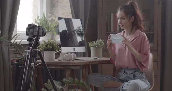 Vlogger Filming In Room Puts A Mask On Her Face