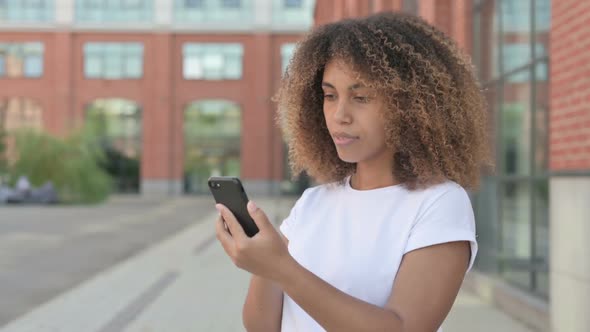 African Woman Celebrating on Smartphone