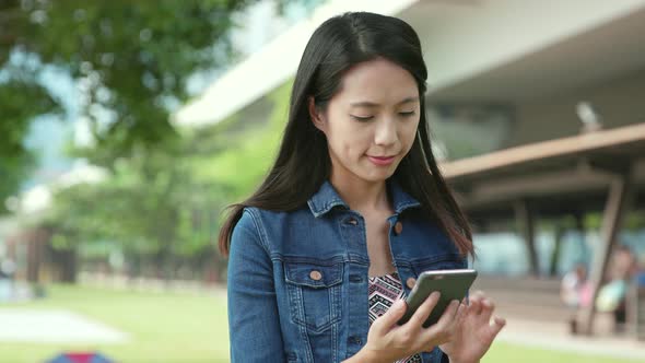 Woman looking at cellphone at outdoor park