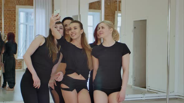 Beautiful Young Women Taking a Selfie During a Break on a Pole Fitness Class