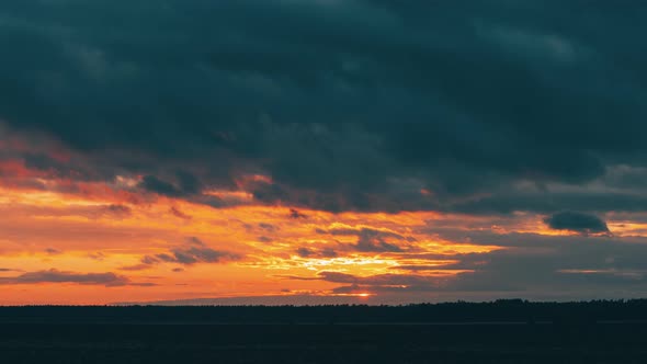 Meadow Field At Evening Sunset. Natural Bright Dramatic Sky Colours Above Countryside Landscape