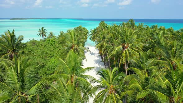 Wide drone island view of a white sand paradise beach and blue water background in colorful 4K