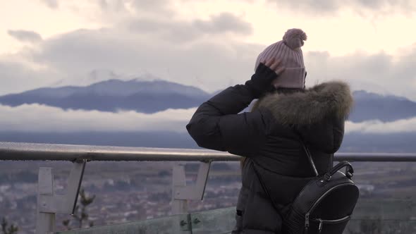 Woman in Winter Clothes Enjoying Beautiful Mountain View From Highrise Roof Balcony