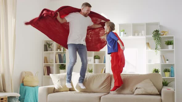 Father and Daughter Jumping on Sofa