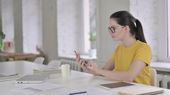 Happy Young Female Designer Talking on Smart Phone