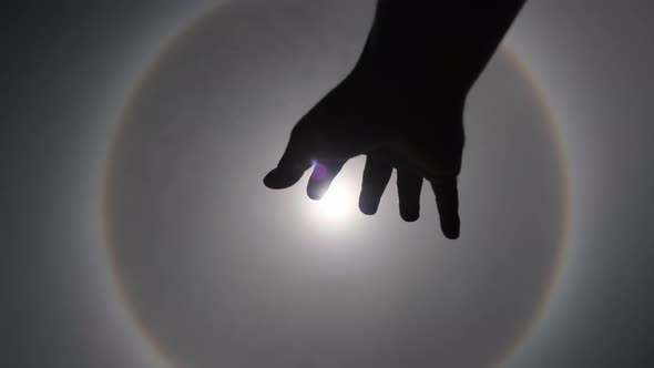 Aerial view of the sun with a circular rainbow surrounded by bright skies.