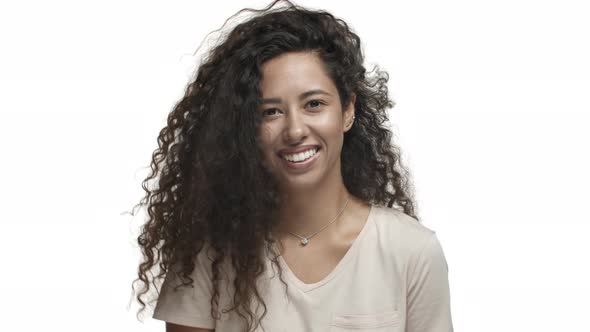 Closeup of Pretty Mexican Woman with Long Curly Hairstyle Dancing and Smiling Coquettish Celebrating