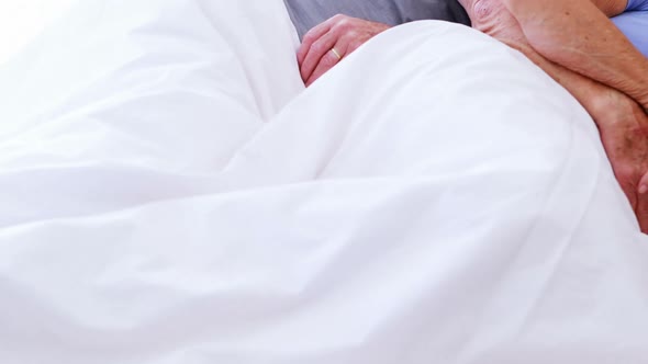 Senior couple sleeping on bed in bedroom