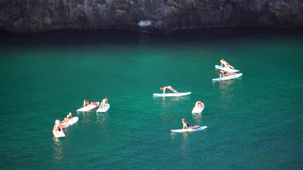 Group of Young Womens in Swimsuit Doing Yoga on Sup Board in Calm Sea Early Morning