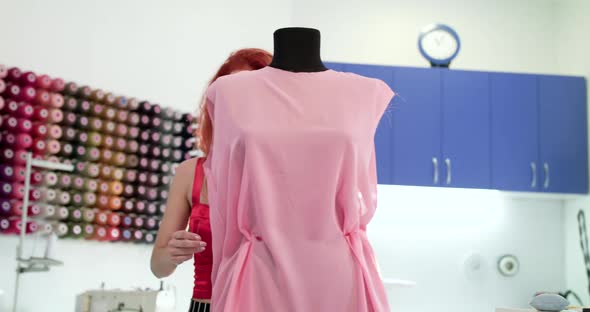 Confident Seamstress Adjusts the Dress on a Mannequin By Pinning the Needles