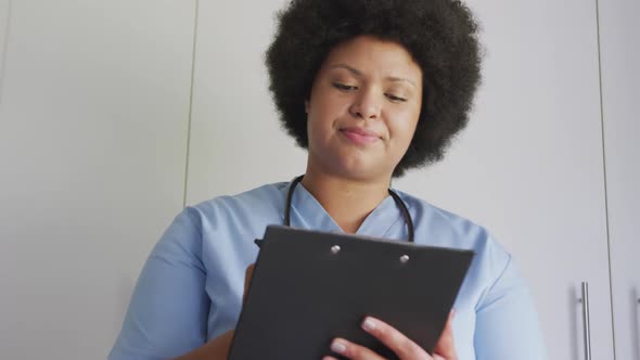 Video of happy plus size african american female doctor using tablet