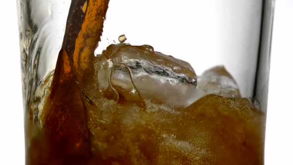 Extreme close-up cola being poured over ice, Slow Motion