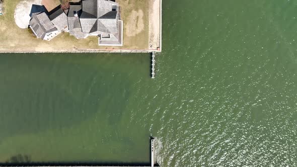 A top down drone view, directly above the shore of the Great Bay in Bay Shore, NY on a sunny day. Th