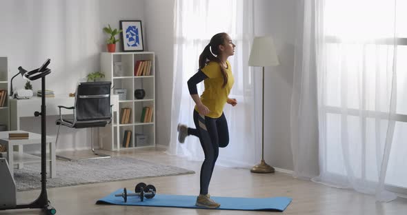 Teenager Girl Is Training Alone in Living Room Doing Aerobics and Gymnastics at Morning Keeping Fit