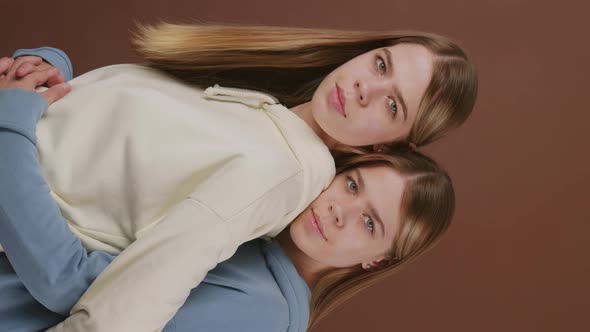 Vertical Portrait of Identical Twins Hugging