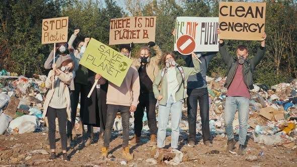 Group of Young Volunteers in Gas Masks Holding Placards