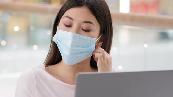 Close Up Asian Girl with Laptop Feels Tired of Pandemic Safety Rules Takes Off Medical Mask Inhales