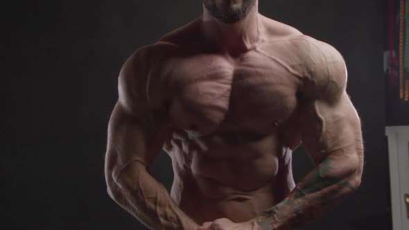 Bodybuilder with Tattoo Strains Pectoral Muscles