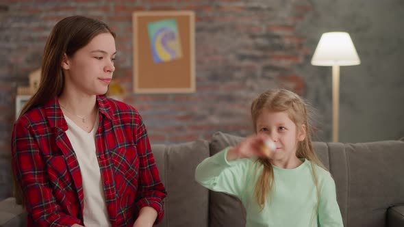 Girl Shakes Bottle with Golden Paint with Elder Sister