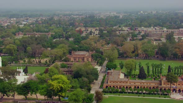 Drone drive of the clean and green city passing over the old heritage buildings, trees and a white m