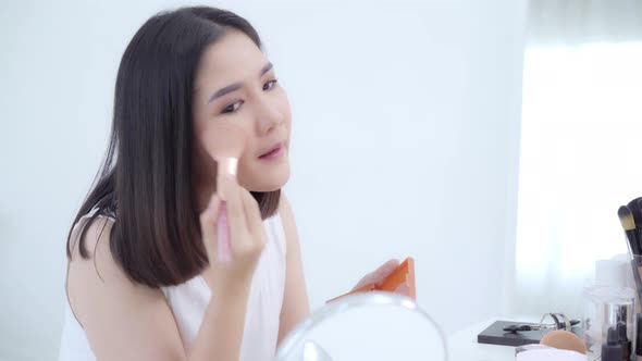 Happy female using beauty cosmetics to improve herself ready to working in bedroom at home.