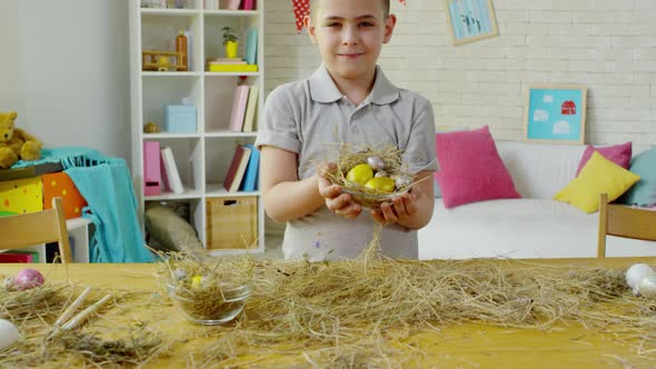 Little Boy Posing with Easter Eggs in Hay Nest alt