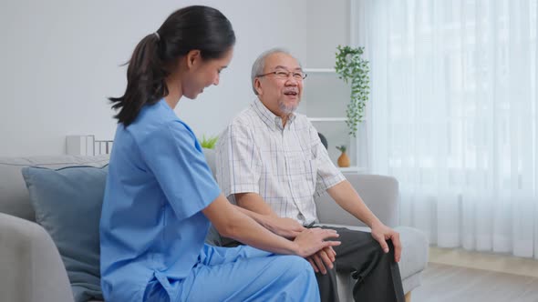 Asian caregiver nurse examine and listen to senior man patient at home.