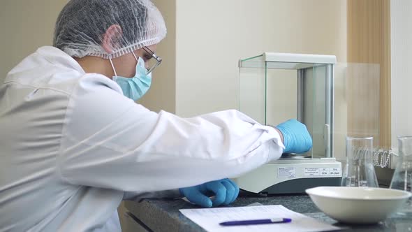 Pharmacist Weighing Dosage of New Produced Pill