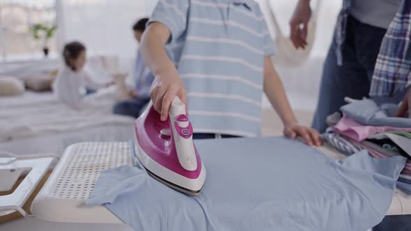 Little Boy Ironing Tshirt Under Dad's Supervision