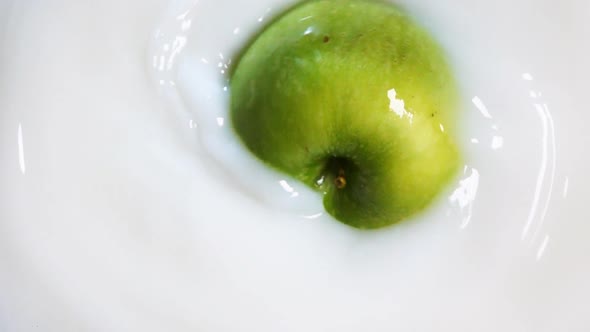 Rotating Green Apple Makes a Swirl in the Milk
