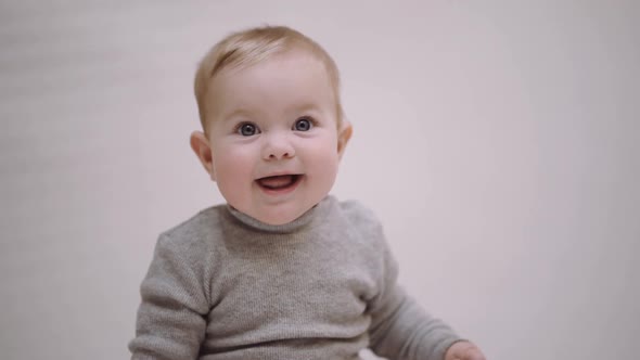 portrait of a 6-month-old baby on a light background and smiling