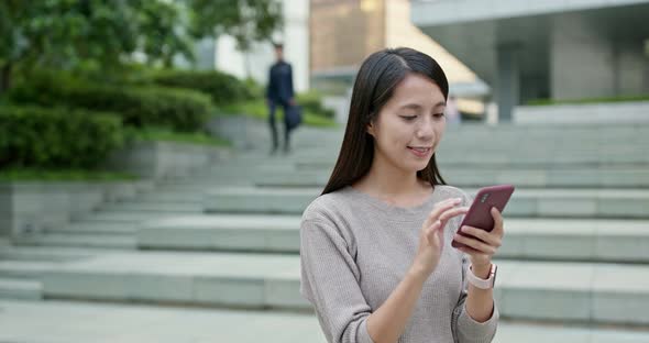 Woman work on smart phone in city