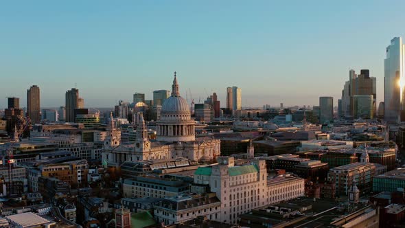 Beautiful cinematic rotating drone shot of St Pauls Cathedral London to modern skyscrapers at sunris